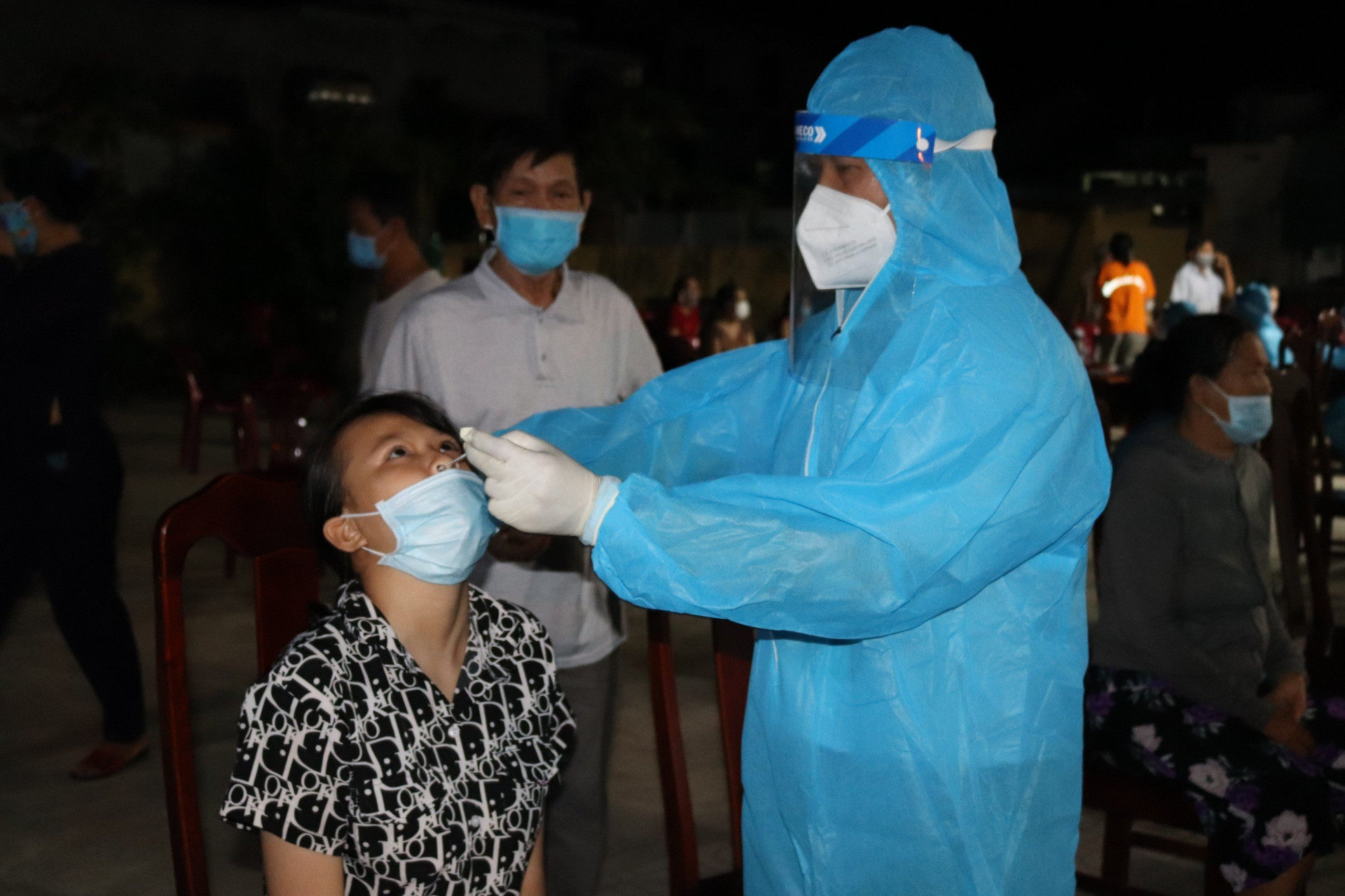 Nhân viên y tế lấy mẫu dịch mũi của người dân để test nhanh.