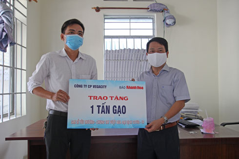 Ông Trần Duy Hưng - Tổng Biên tập Báo Khánh Hòa (bên phải) trao quà hỗ trợ của Công ty Cổ phần VegaCity cho người dân phường Vĩnh Trường.