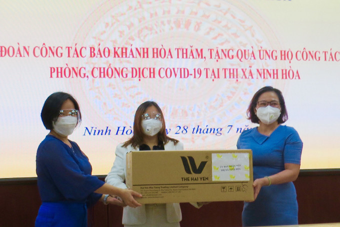 Bà Thái Thị Lệ Hằng (bên trái) cùng với doanh nghiệp trao tặng phần quà cho UBND thị xã Ninh Hoà