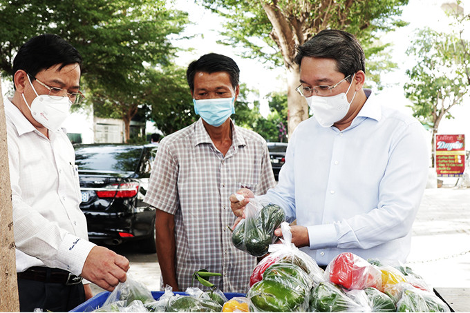 Đồng chí Nguyễn Hải Ninh - Ủy viên Trung ương Đảng, Bí thư Tỉnh ủy (bìa phải)  kiểm tra điểm bán hàng thiết yếu lưu động tại phường Phước Long. 