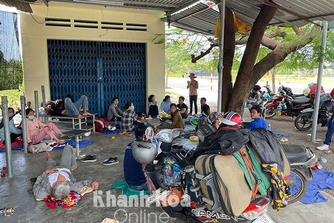 Đoàn người từ TP. Hồ Chí Minh về Nghệ An nghỉ ngơi bên đường ở phường Cam Nghĩa sau khi nhận cơm từ thiện dọc đường.