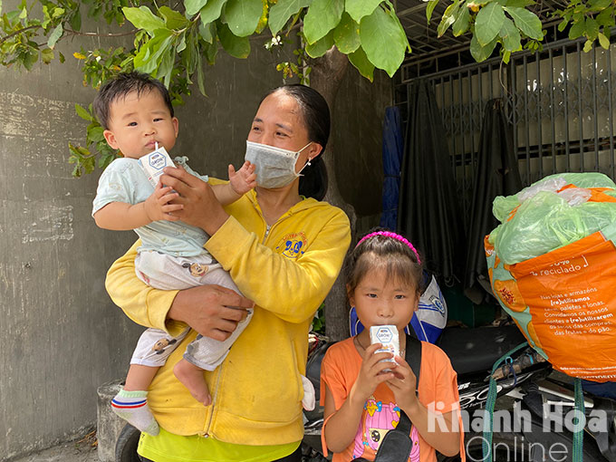 Chị Đinh Thị Vinh cùng con trai 9 tháng tuổi và con gái 7 tuổi trên đường về Nghệ An vui mừng nhận cơm và sữa miễn phí từ người dân TP. Cam Ranh.