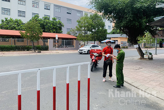 Công an xã Vinh Ngọc kiểm tra giấy tờ đi đường của một shipper đến giao hàng tại khu đô thị Vĩnh Điềm Trung, Nha Trang