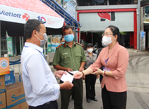 Bà Phạm Thị Xuân Trang trao quà cho lực lượng làm nhiệm vụ tại chốt kiểm tra, kiểm soát phòng chống dịch Covid-19 xã Vĩnh Thạnh (trên đường 23-10).