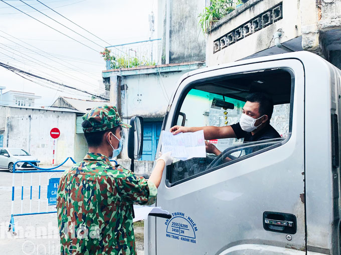 Hạ sĩ Tạ Đào Quốc Minh – học viên Trường Sĩ quan thông tin kiểm tra giấy tờ của người đi đường tại điểm chốt kiểm soát ở đường Ngô Đến, phường Vĩnh Phước.