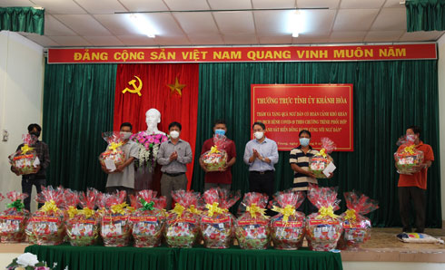 Ông Nguyễn Hải Ninh và ông Hồ Văn Mừng tặng quà cho các hộ ngư dân khó khăn tại UBND phường Vĩnh Nguyên.