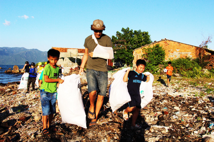 Một người nước ngoài tham gia nhặt rác cùng người dân tại bãi biển Vĩnh Lương (TP. Nha Trang). Ảnh chụp năm 2020