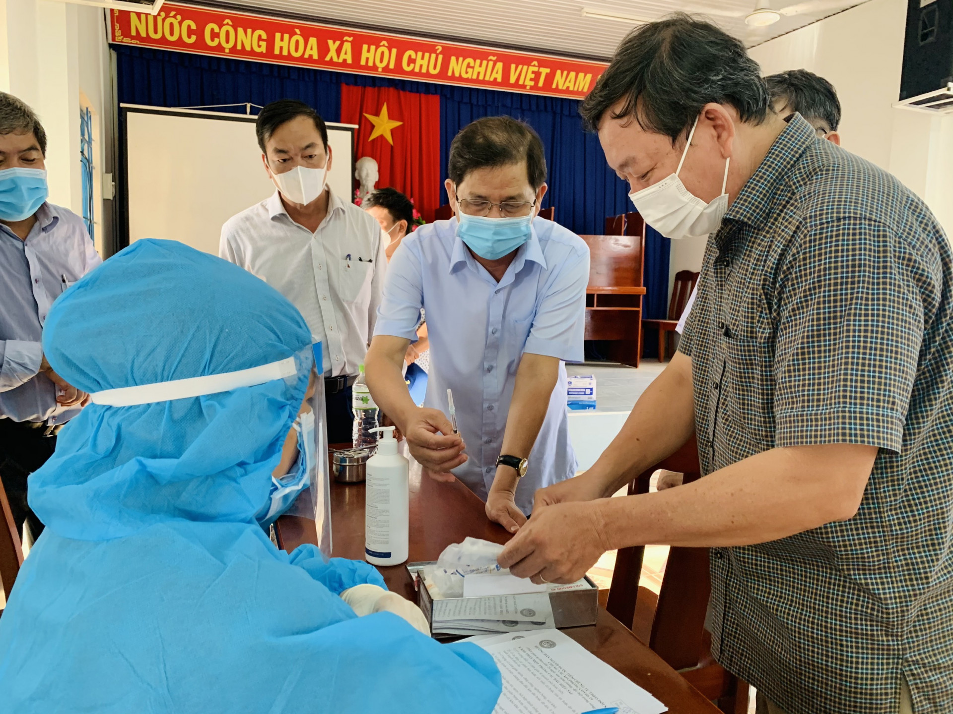  Ông Nguyễn Tấn Tuân trao đổi với lực lượng y tế về quy trình xử lý các trường hợp bị phản ứng phụ sau khi tiêm