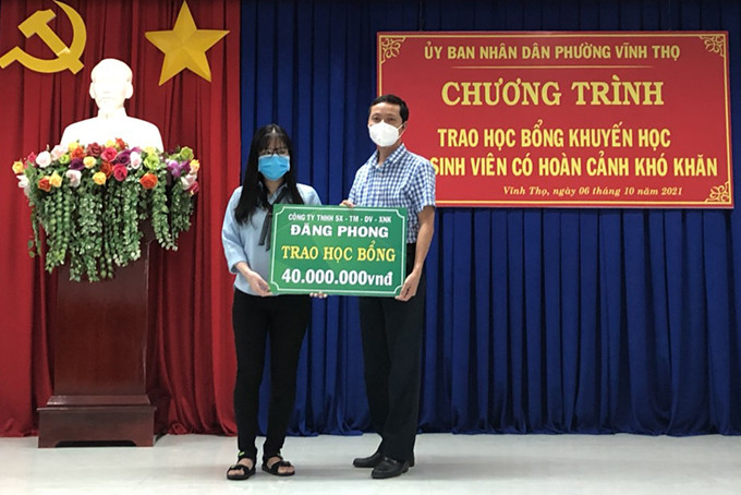 Đại diện Công ty TNHH-SX-TM-XNK Đăng Phong trao bảng tượng trưng học bổng cho sinh viên Ngô Thị Ngọc Ánh