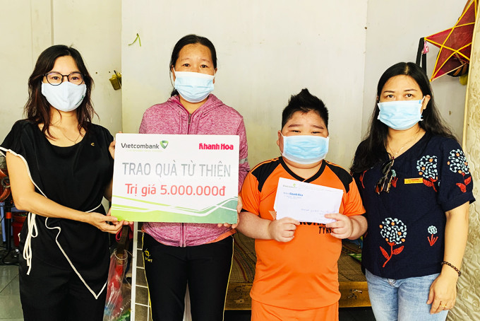 Đại diện Báo Khánh Hòa và Vietcombank Nha Trang trao tiền ủng hộ  cho gia đình cháu Nguyễn Tấn Đạt.