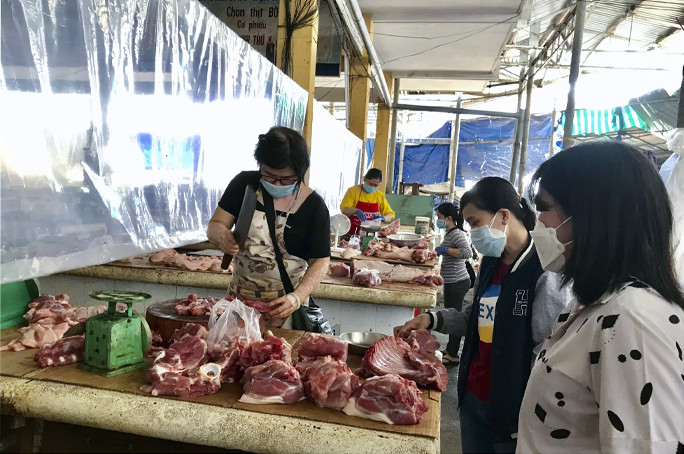 Người dân mua thịt heo tại chợ Xóm Mới. 