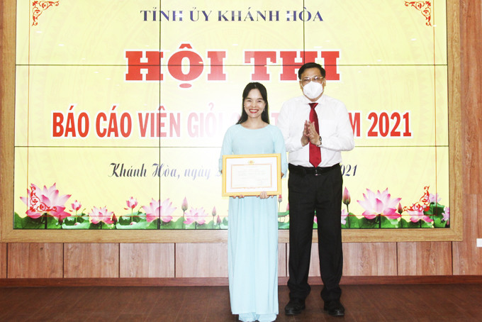 Đồng chí Lê Hữu Thọ trao giải nhất cho  báo cáo viên Nguyễn Thị Kim Dung.