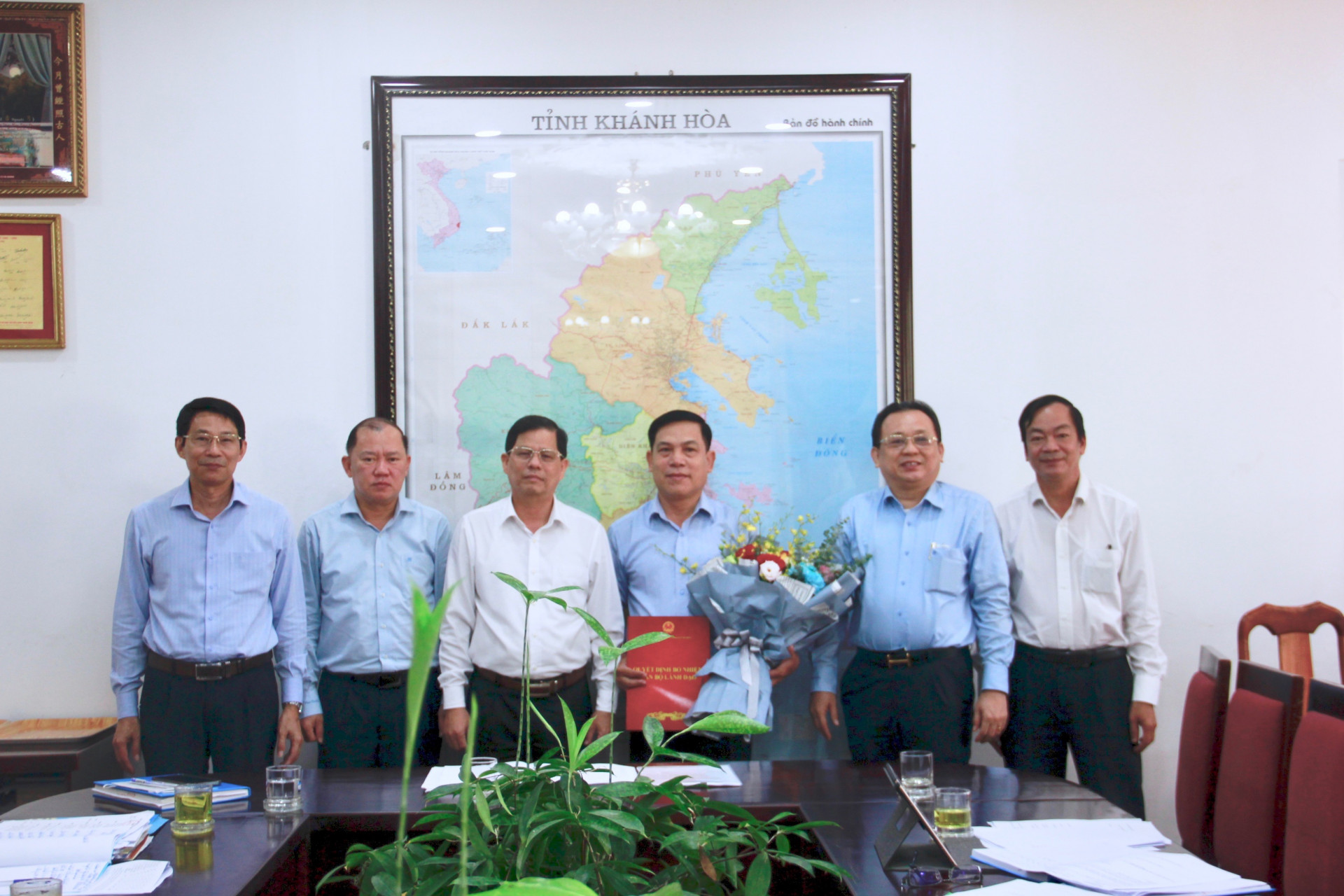 Ông Nguyễn Tấn Tuân (thứ 3 từ trái sang) trao quyết định và tặng hoa chúc mừng ông Cao Thanh Vũ