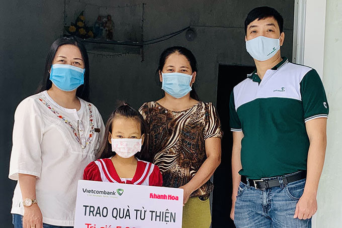 Đại diện Báo Khánh Hòa và Vietcombank Nha Trang trao tiền ủng hộ cho gia đình cháu Thái Nguyễn Anh Thư