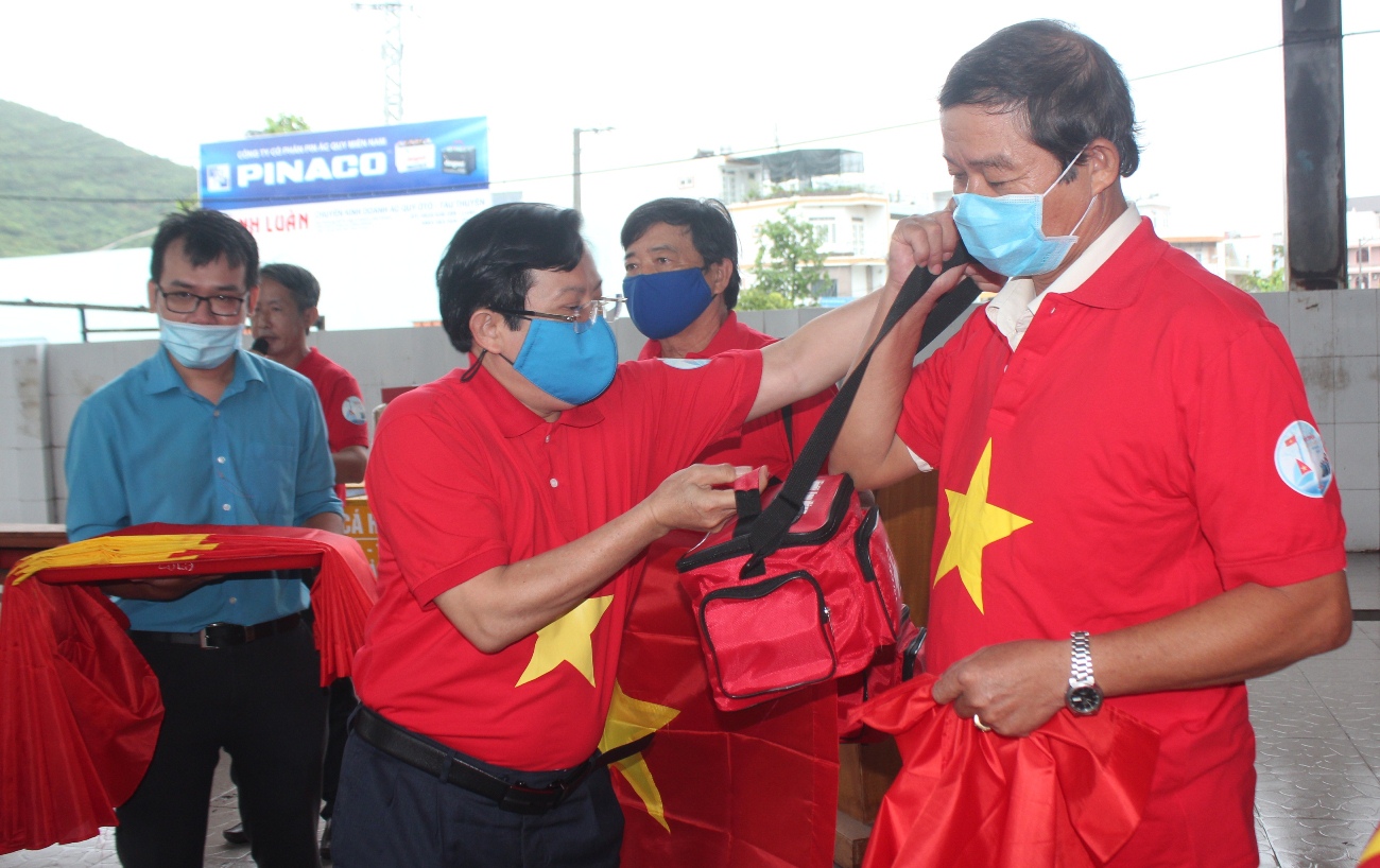 Ông Tô Đình Tuân - Tổng biên tập Báo Người Lao Động trao cờ và túi thuốc cho ngư dân Khánh Hòa.