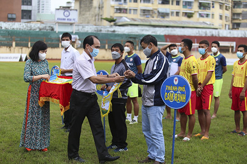 Nguyen Tuan Thanh, deputy director of Khanh Hoa Provincial Department of Culture and Sports offering souvenir flags to teams