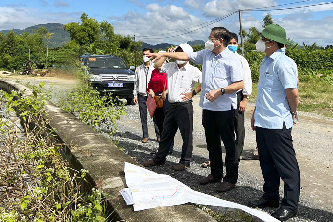Đồng chí Hồ Văn Mừng (bìa phải) kiểm tra điểm thoát nước sông Tắc - cầu Phú Vinh. 