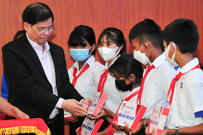 Ông Nguyễn Tấn Tuân trao máy tính bảng cho các học sinh