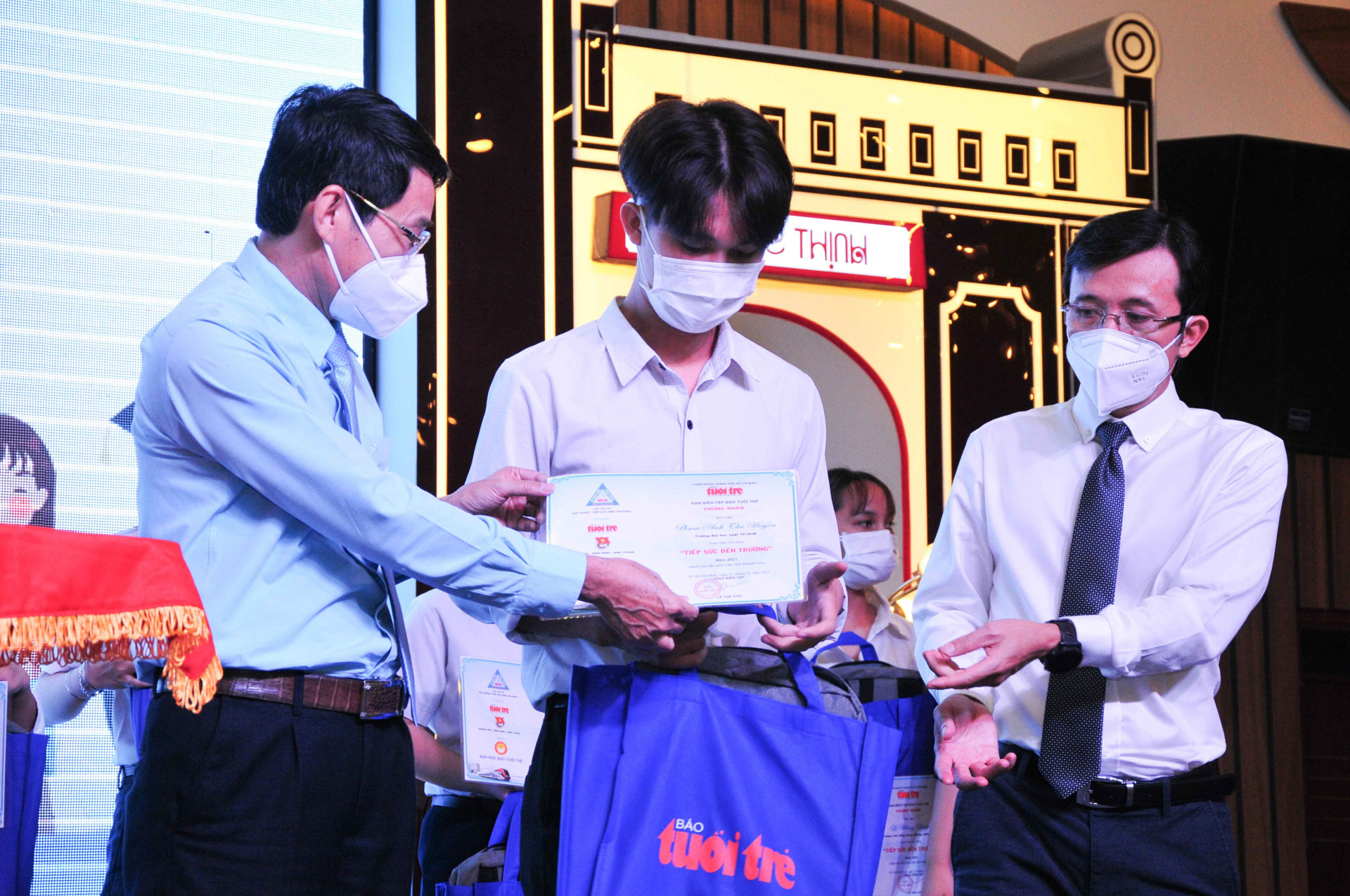 Ông Đinh Văn Thiệu (bìa trái) cùng đại diện Báo Tuổi Trẻ trao học bổng cho học sinh