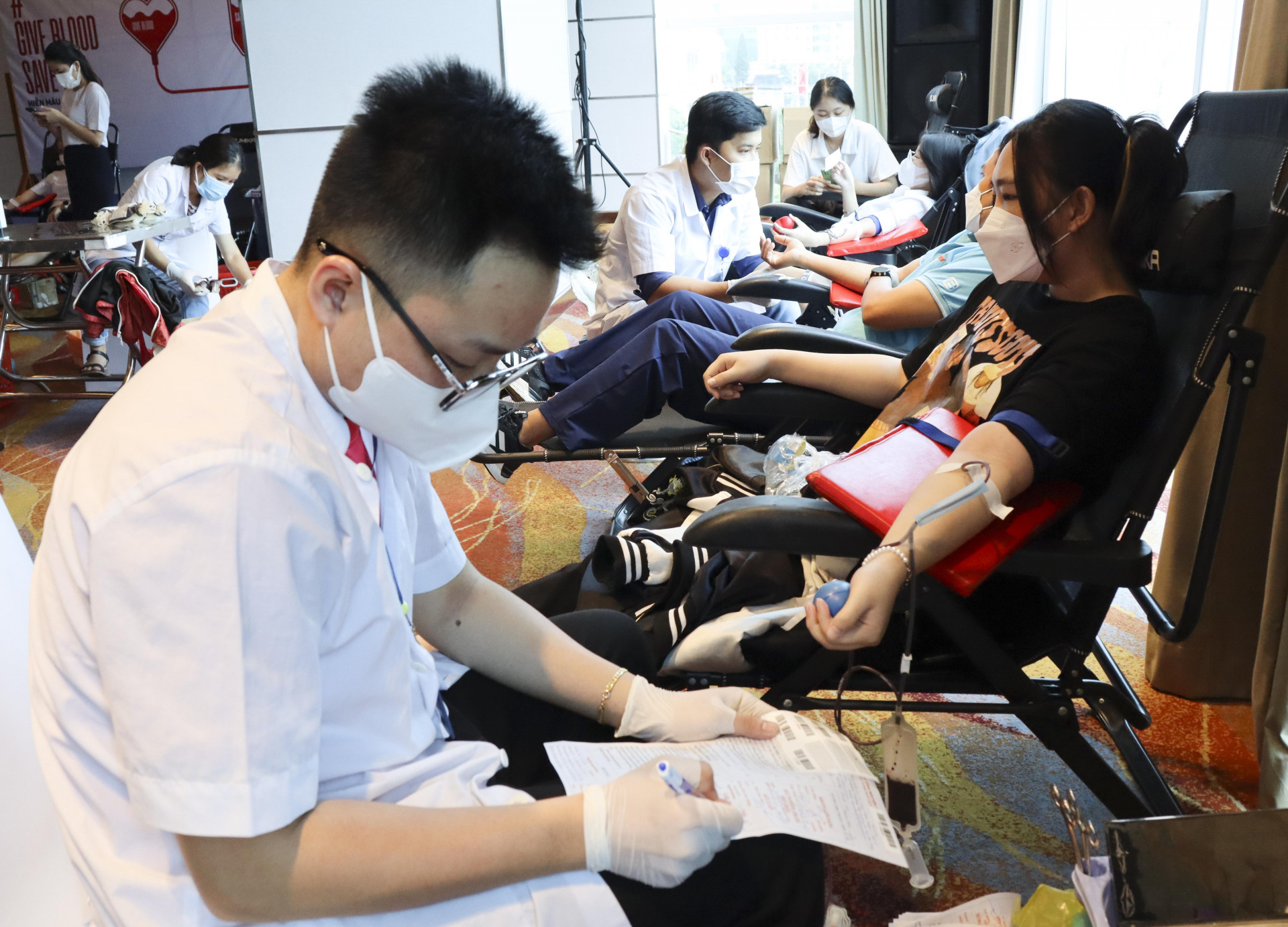 Bác sĩ kiểm tra thông tin của người hiến máu tình nguyện