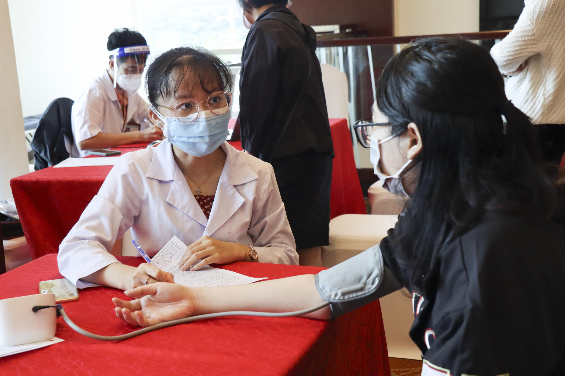 Người hiến máu tình nguyện được đo huyết áp kiểm tra sức khỏe trước khi vào hiến máu