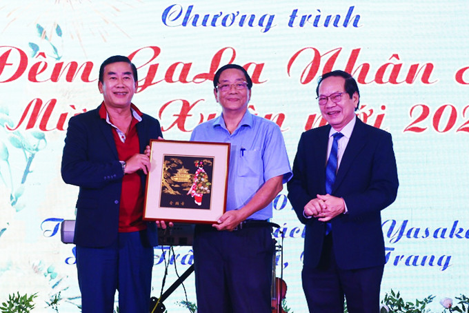 Ông Trương Tấn Minh (bên phải) - Chủ tịch Hội Bảo trợ người tàn tật,  trẻ mồ côi và bệnh nhân nghèo tỉnh trao bức tranh đấu giá từ thiện  cho một mạnh thường quân.