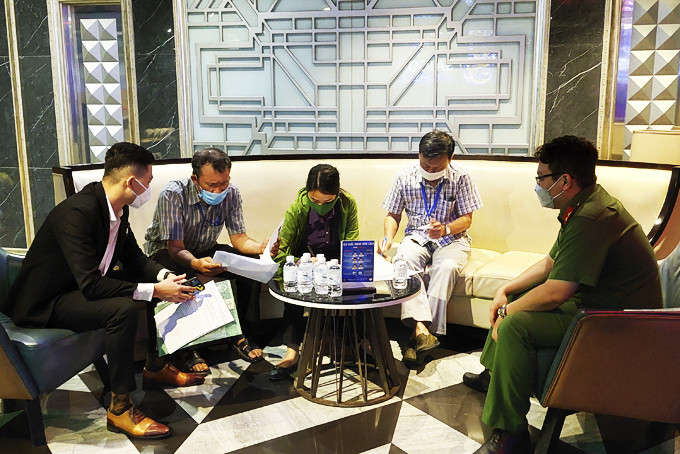 Các thành viên Đội kiểm tra liên ngành văn hóa - thông tin TP. Nha Trang làm việc với đại diện cơ sở karaoke Quinter Central. 