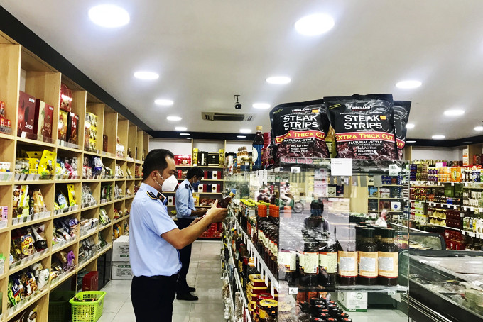 Lực lượng quản lý thị trường kiểm tra hàng hóa phục vụ Tết tại một cửa hàng ở TP. Nha Trang.