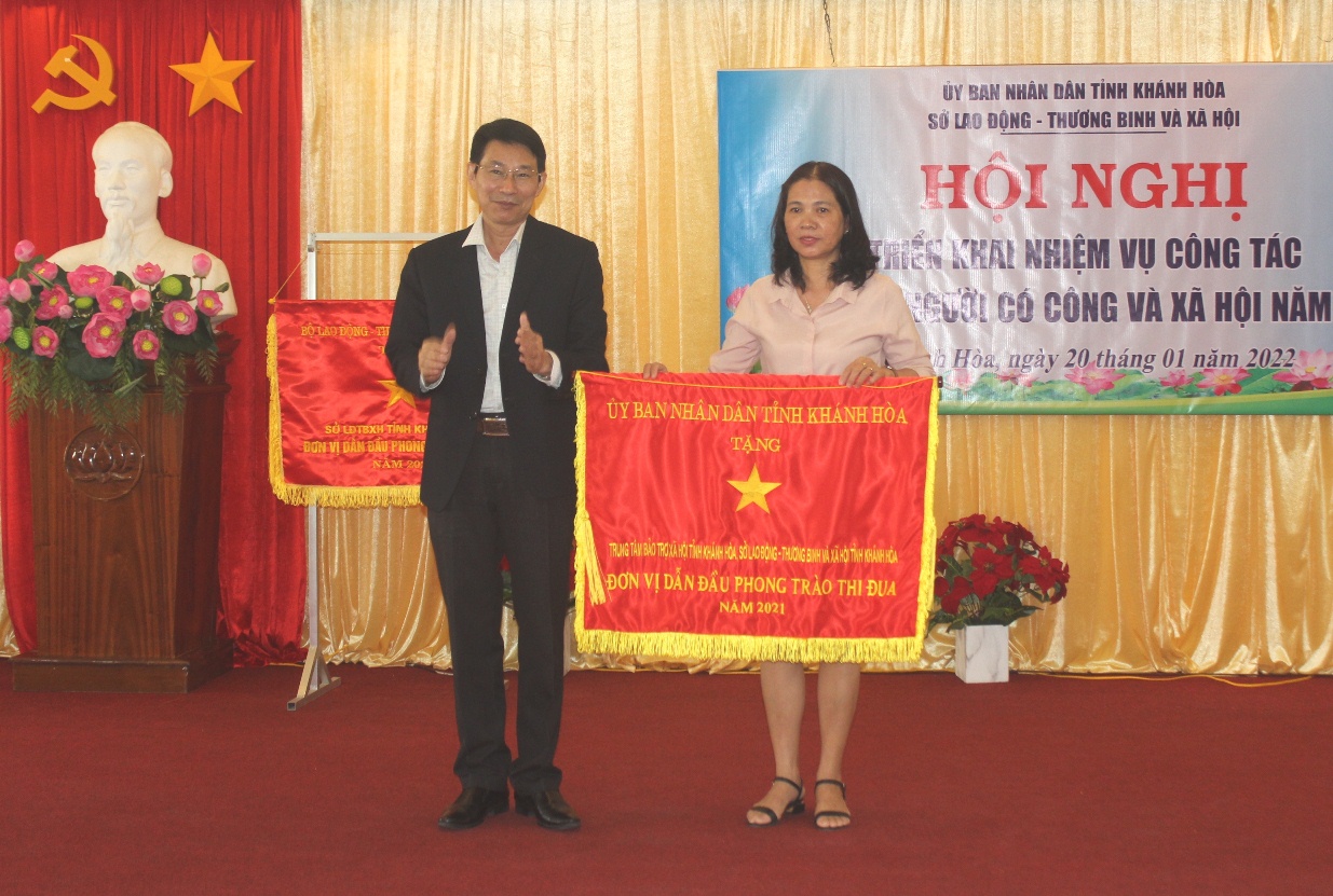 Ông Đinh Văn Thiệu trao cờ thi đua xuất sắc cho Trung tâm Bảo trợ xã hội tỉnh.