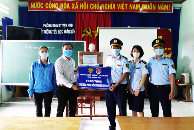 Lực lượng quản lý thị trường tỉnh trao khẩu trang y tế cho Trường Tiểu học Xuân Sơn (huyện Vạn Ninh).