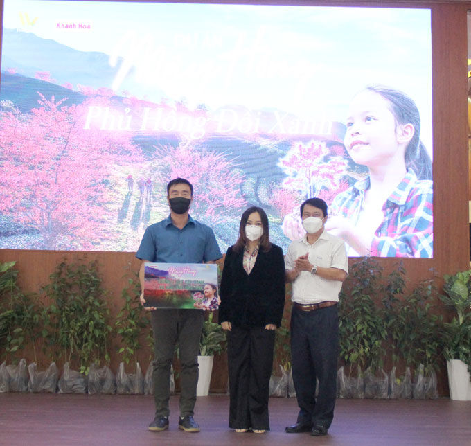 Lãnh đạo Báo Khánh Hòa, Công ty TNHH MTV Hải Yến Nha Trang trao bảng tượng trưng tặng 1.000 cây hoa anh đào cho huyện Khánh Sơn.