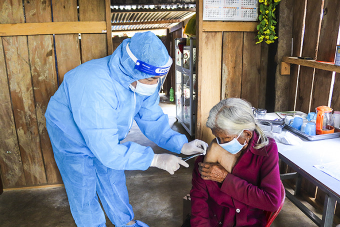 Cán bộ y tế xã Ba Cụm Bắc tiêm vắc xin tại nhà bà Mấu Thị Nương (thôn Dốc Trầu).