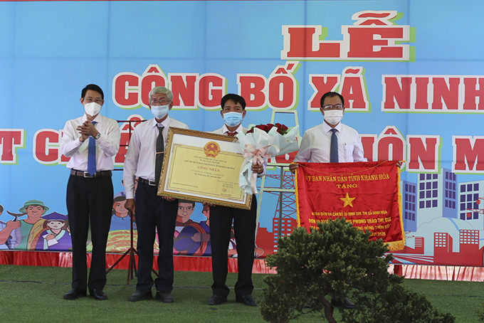 Ông Đinh Văn Thiệu trao bằng công nhận xã Ninh Sim đạt chuẩn nông thôn mới và trao tặng Cờ thi đua của tỉnh.