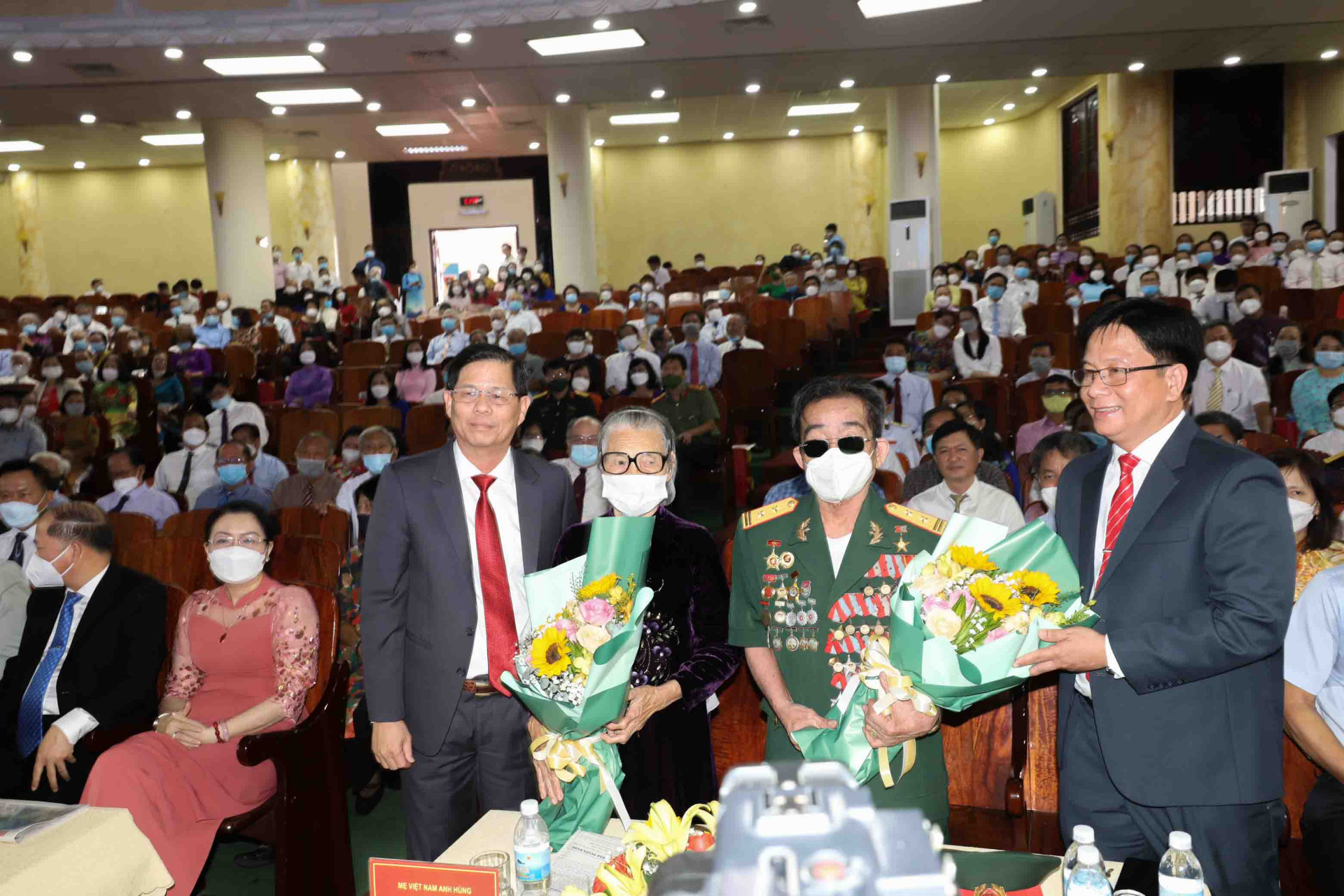 Ông Nguyễn Tấn Tuân và ông Hồ Văn Mừng tặng hoa Mẹ Việt Nam Anh hùng Đào Thị Lưu và Anh hùng lực lượng vũ trang Nguyễn Đức Quân. 