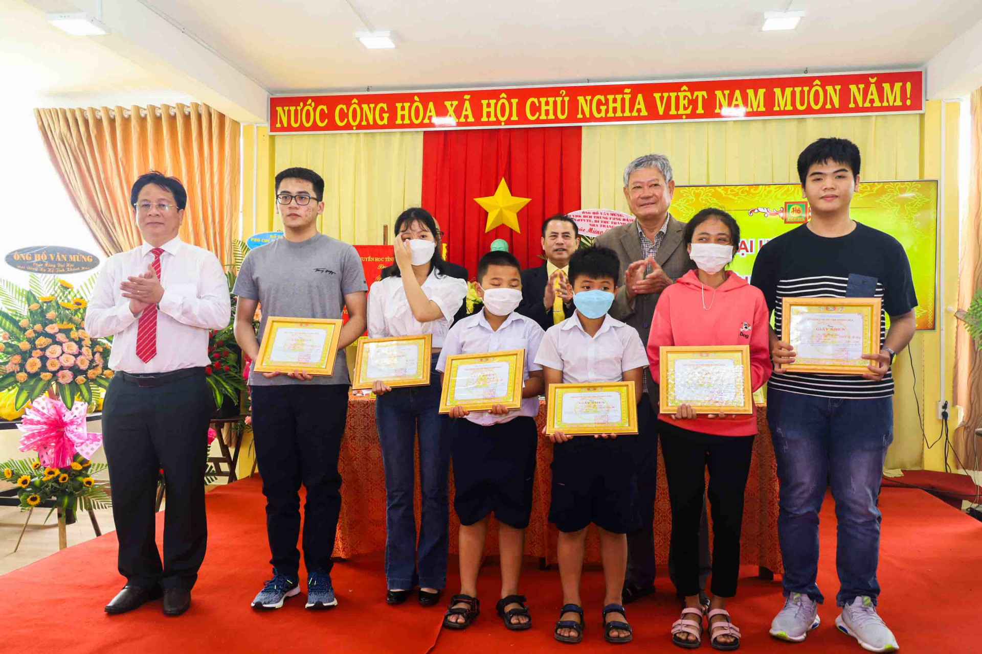 Ông Hồ Văn Mừng (bìa trái) trao thưởng cho các em học sinh có thành tích học tập tốt. 