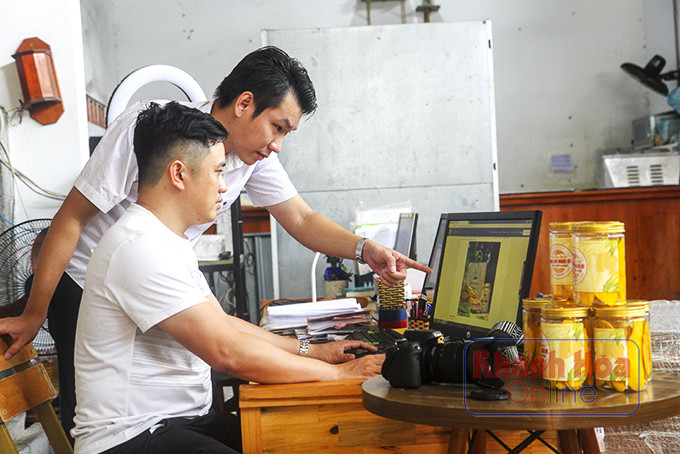  Anh Truyền (ngồi) và anh Phong xử lý hình chụp đặc sản trước khi đưa lên sàn.
