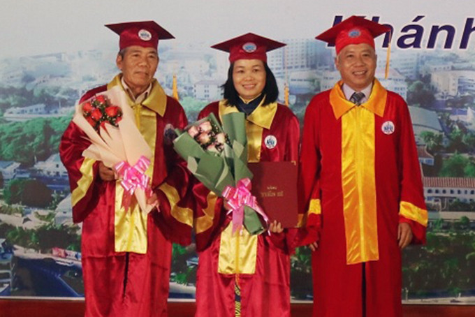 Hiệu trưởng Trường Đại học Nha Trang trao bằng tốt nghiệp cho tân tiến sĩ và tặng hoa cho giảng viên hướng dẫn.