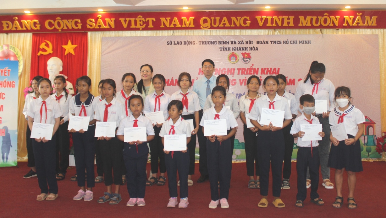 Ông Đinh Văn Thiệu và bà Phạm Thị Xuân Trang trao học bổng cho học sinh vượt khó học tập tốt.