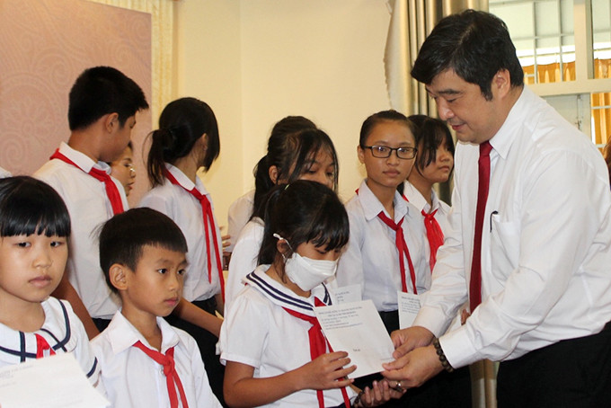 Ông Tạ Hồng Quang - Giám đốc Sở Lao động - Thương binh và Xã hội trao học bổng cho học sinh vượt khó học tập tốt.