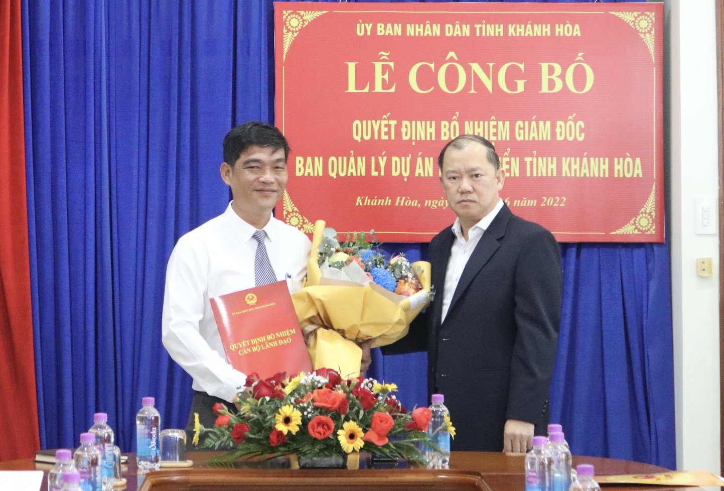 Ông Nguyễn Anh Tuấn trao quyết định và tặng hoa chúc mừng ông Hồ Tấn Quang.