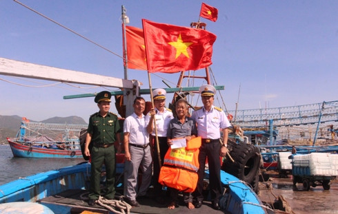 Tặng cờ Tổ quốc và áo phao cho ngư dân tại cảng cá Đá Bạc.