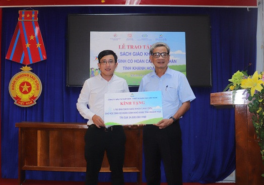 Đại diện Sở Giáo dục và Đào tạo Khánh Hòa (bên phải) tiếp nhận tượng trưng bộ sách giáo khoa từ Công ty VEPIC.