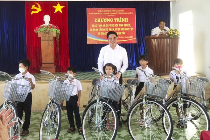 Ông Nguyễn Khắc Toàn trao tặng xe đạp cho các em học sinh.