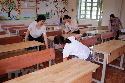 Giáo viên Trường THCS thị trấn Than Uyên lau dọn vệ sinh phòng, lớp học kê lại bàn ghế chuẩn bị cho năm học mới 2022-2023. (Ảnh: Quý Trung/TTXVN)