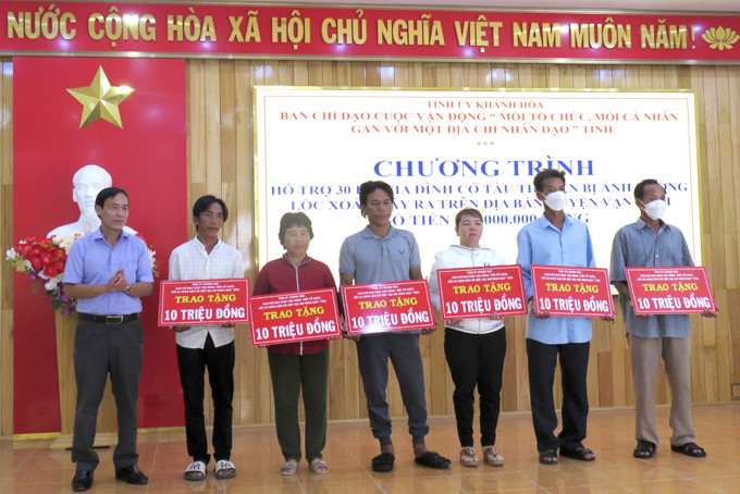 Lãnh đạo Huyện ủy Vạn Ninh trao biểu trưng hỗ trợ cho các gia đình. 