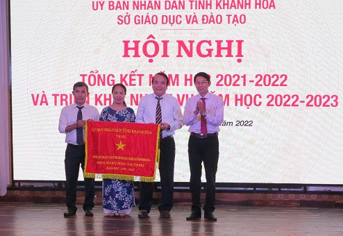 Ông Đinh Văn Thiệu trao cờ thi đua của UBND tỉnh cho Trường THPT Chuyên Lê Quý Đôn. 