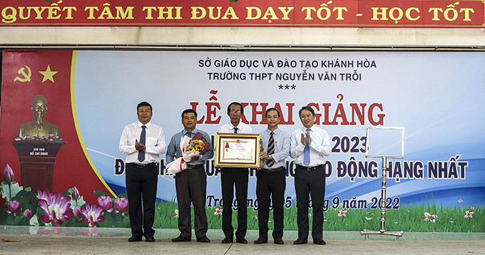 Thừa ủy quyền của Chủ tịch nước, ông Nguyễn Hải Ninh trao Huân chương lao động hạng Nhất cho Trường THPT Nguyễn Văn Trỗi.