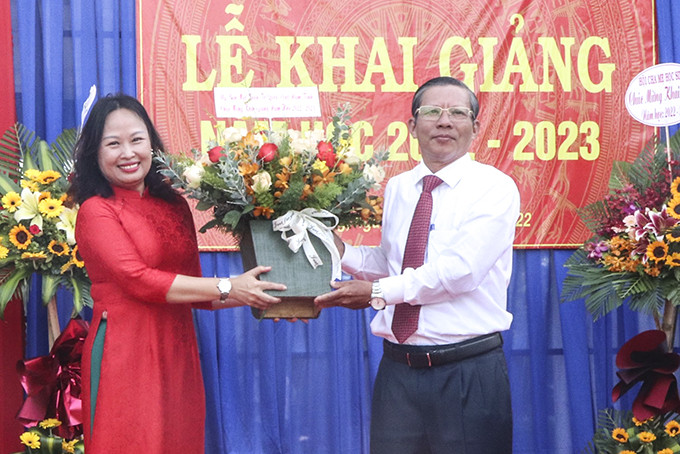 Ông Trần Ngọc Thanh tặng hoa chúc mừng thầy và trò Trường THPT Phạm Văn Đồng trong lễ khai giảng năm học mới.