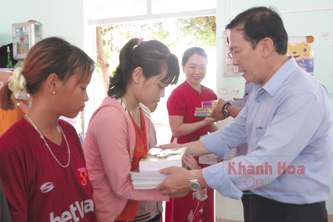 Ông Trần Nguyên Lập -Trưởng phòng Giáo dục và Đào tạo TP. Nha Trang trao tặng sách vở cho học sinh.