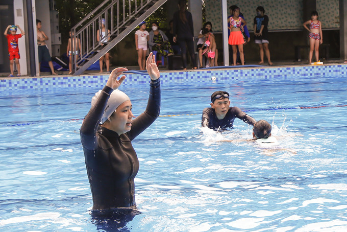 Huấn luyện viên của Câu lạc bộ bơi lội Vĩnh Hải (Nha Trang)  hướng dẫn động tác bơi cho các em nhỏ.